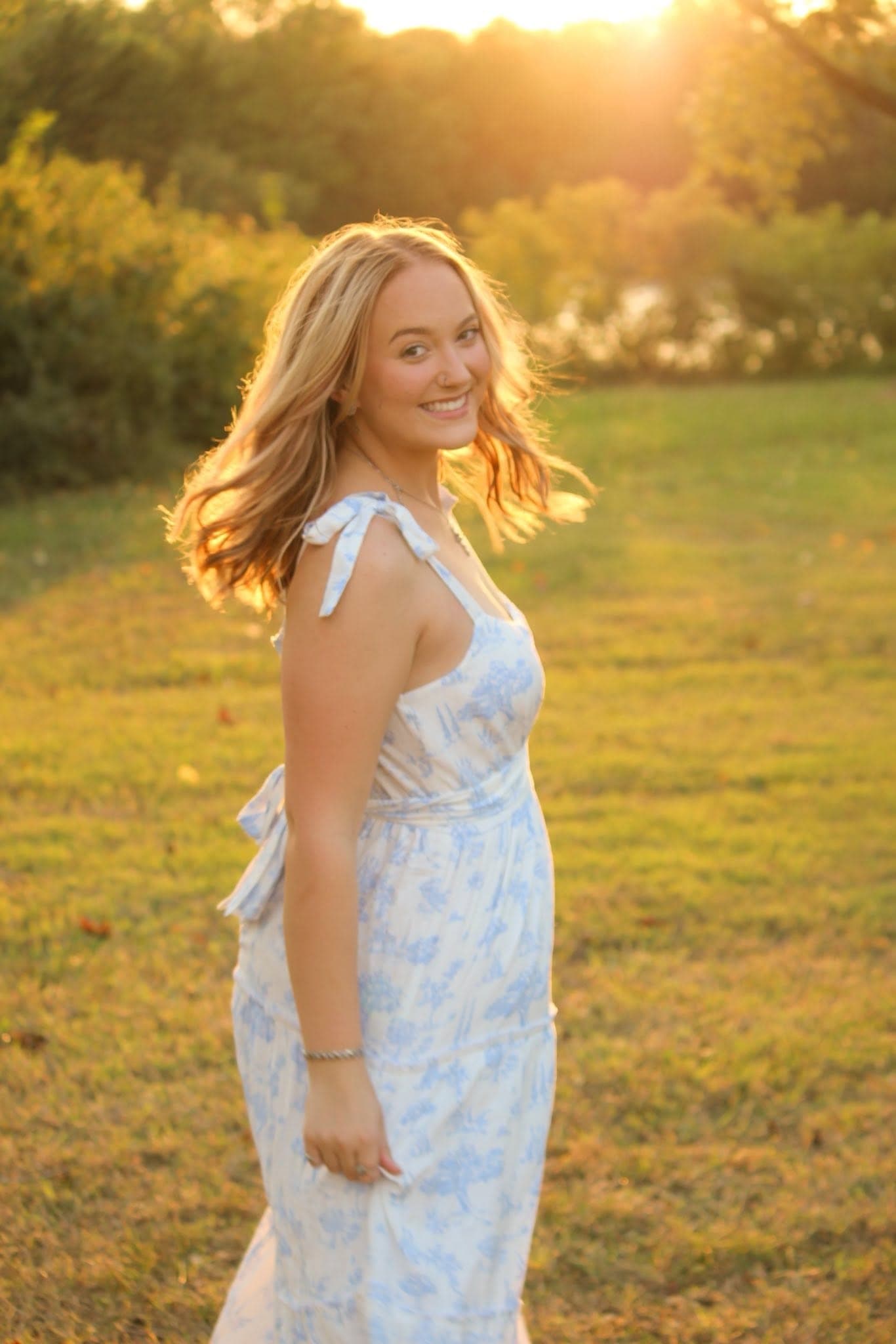 Young woman twirling her hair in golden hour light